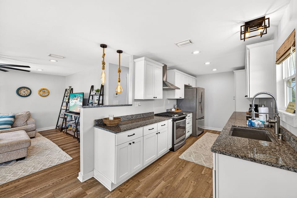 Picture yourself cooking in this bright, fully-equipped kitchen, where granite countertops, modern stainless appliances, and coastal touches create a welcoming space to gather and share meals together.