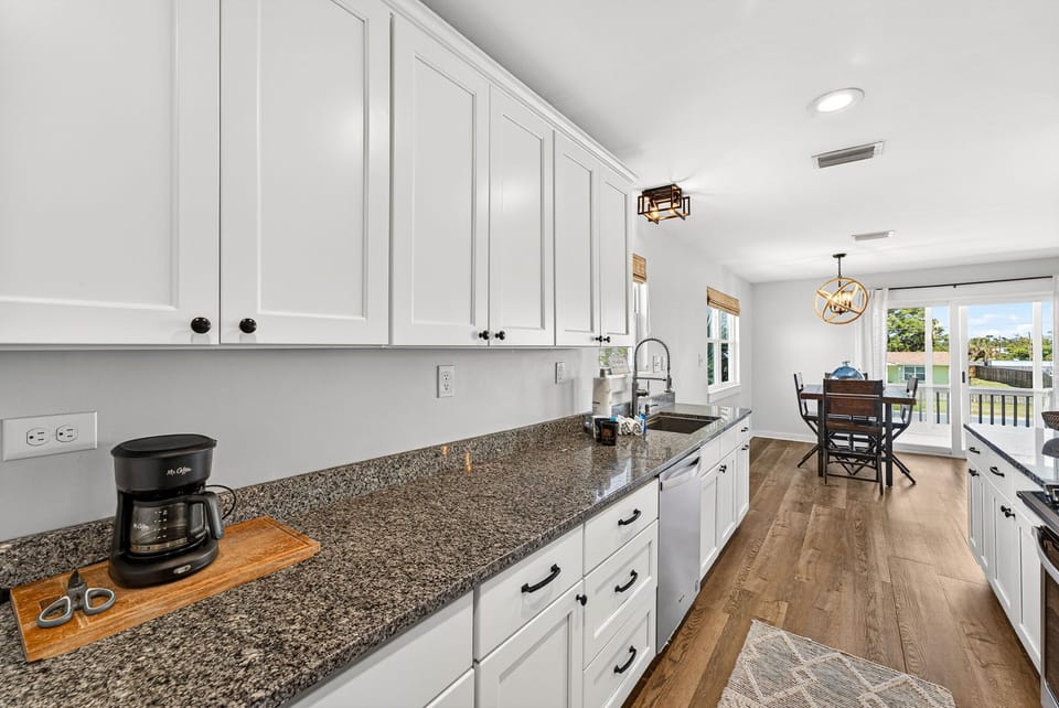 Step into a bright, modern kitchen where your morning coffee awaits. Gleaming countertops, ample prep space, and warm wood floors invite you to cook with ease. Sunlight streams through the dining area, perfect for your leisurely meals.