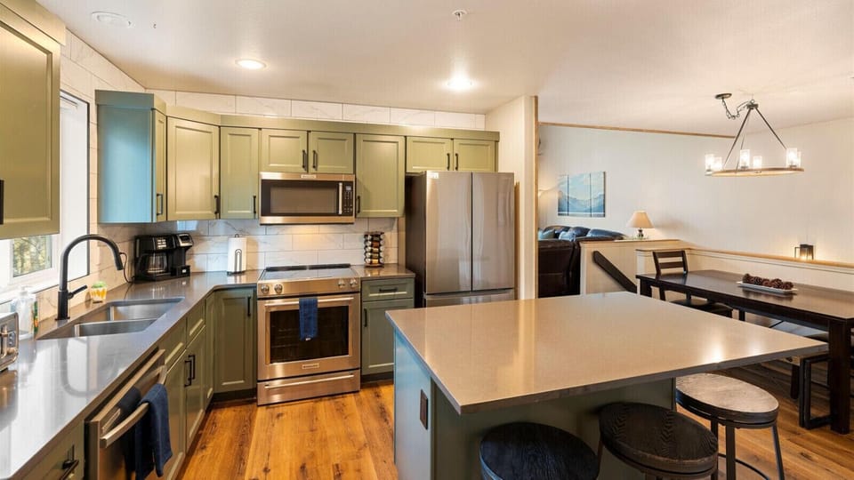 Newly remodeled open concept fully stocked kitchwn with breakfast bar seatying for 45 and access to deck with hot tub, outdoor dining space, and BBQ grill