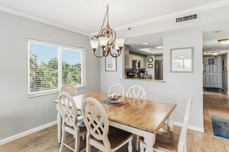 Gather around the table for meals and memories in this bright dining space with a view of the kitchen, perfect for your group to reconnect and share stories over delicious home-cooked meals.