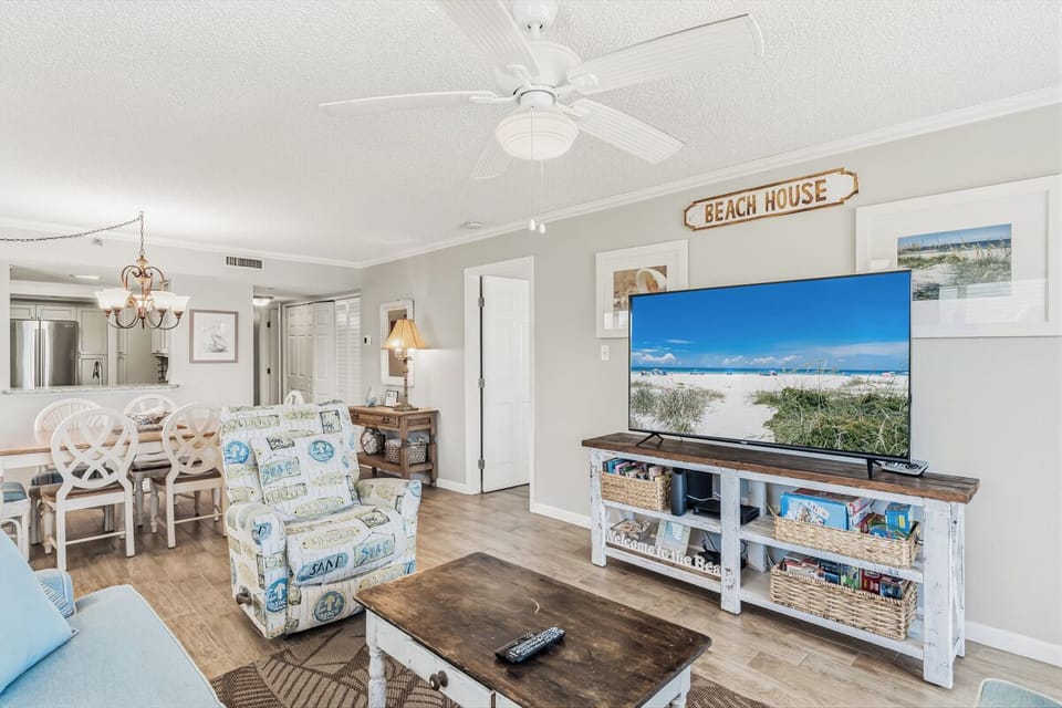 Your beach-themed retreat features coastal decor, cozy seating, and a large TV for relaxing evenings after sun-soaked days.