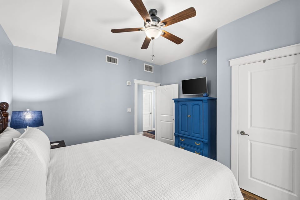 Drift off under a peaceful sky-blue ceiling fan, surrounded by calming tones and thoughtful touches. Your private retreat awaits with comfort, entertainment, and serene style.