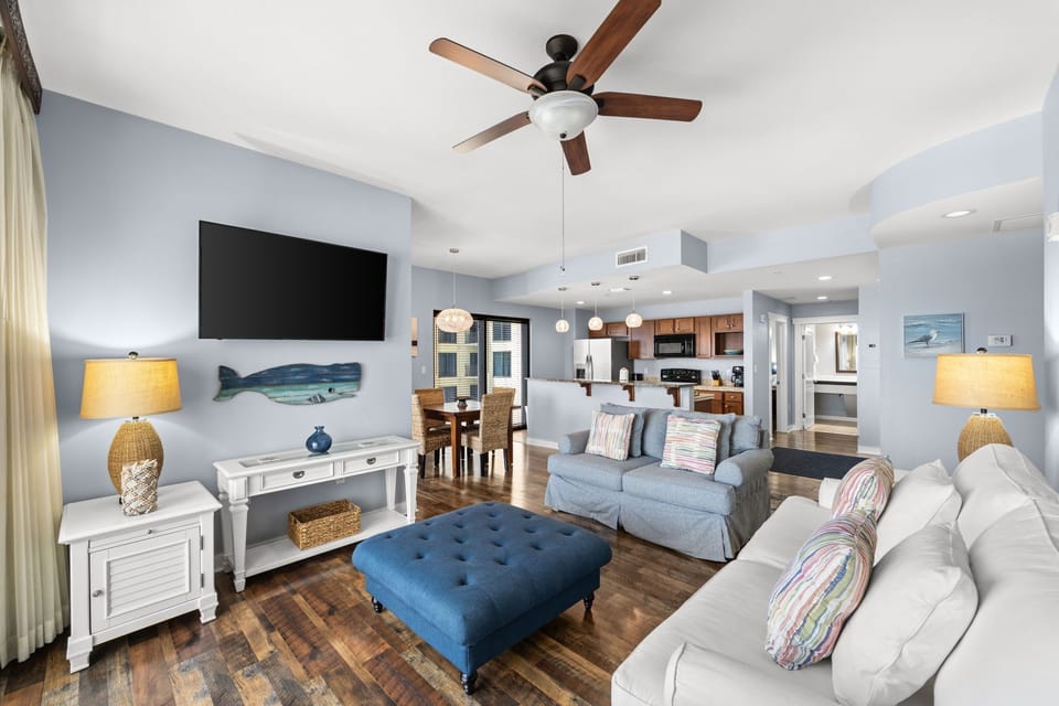 Unwind in your spacious open-concept living area, where coastal décor and soft lighting create a serene retreat. Enjoy the dining space and fully equipped kitchen, perfect for memorable meals together.
