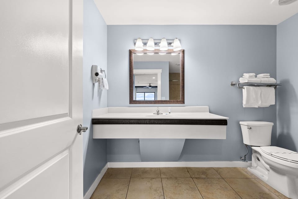 Refresh in your bright, spacious bathroom with plush towels at your fingertips, a well-lit vanity, and a peaceful blue palette that makes morning routines feel effortless.