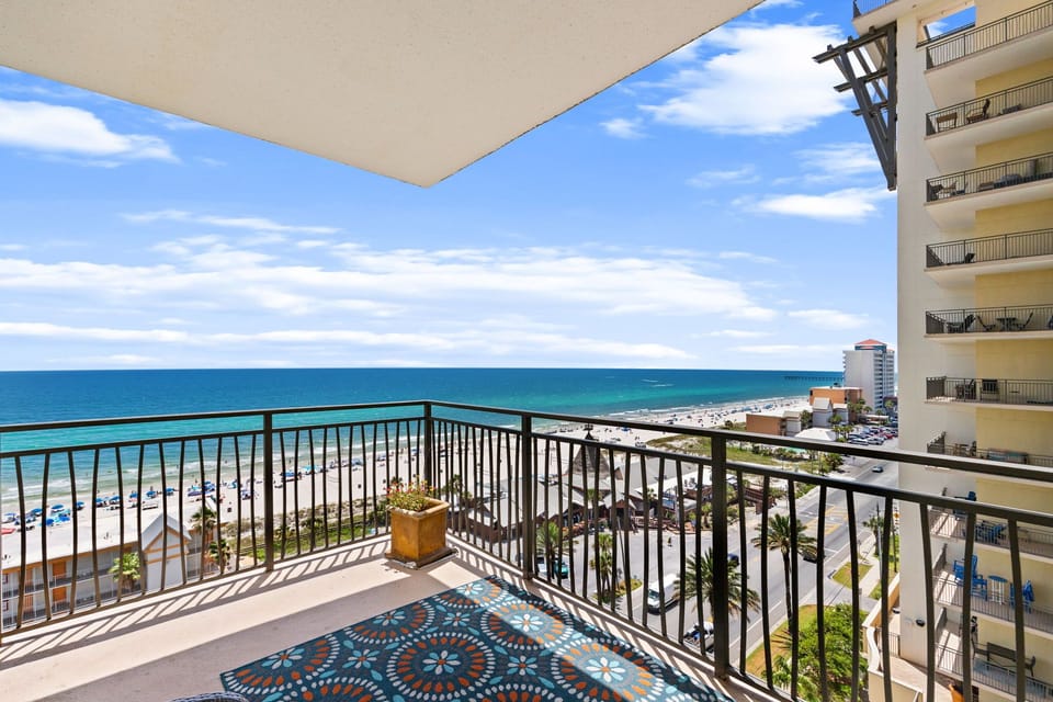 Balcony overlooking pristine beaches and turquoise waves under a bright blue sky, inviting relaxation and coastal views.