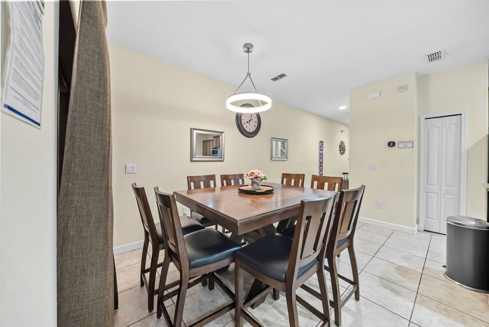 Gather around our sturdy wooden dining table, surrounded by cozy chairs perfect for sharing meals and conversations. The warm pendant light and tasteful decor create a welcoming atmosphere for you and your guests.