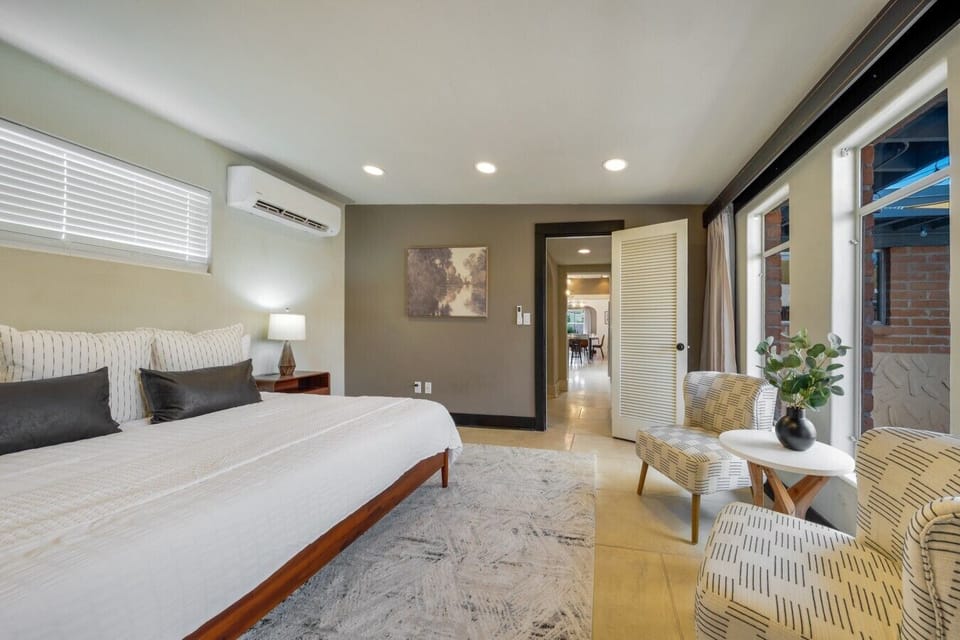 Spacious and light-filled, the primary bedroom offers a king bed and a relaxing seating area