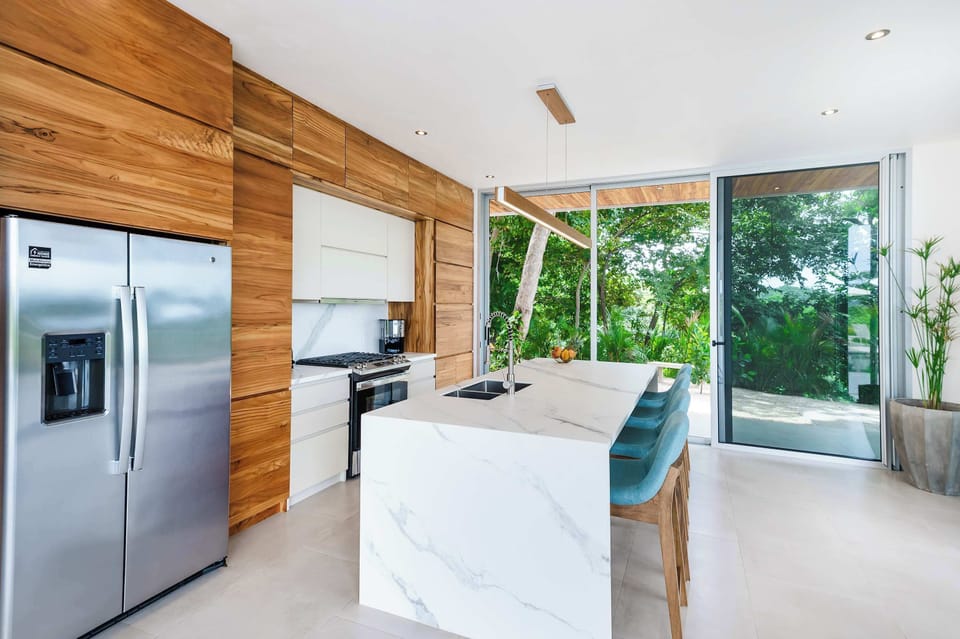 Sleek kitchen surrounded by lush views.