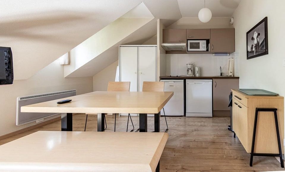 The kitchenette sits under the sloped roofline, stocked for cooking between days on the trails or pistes.