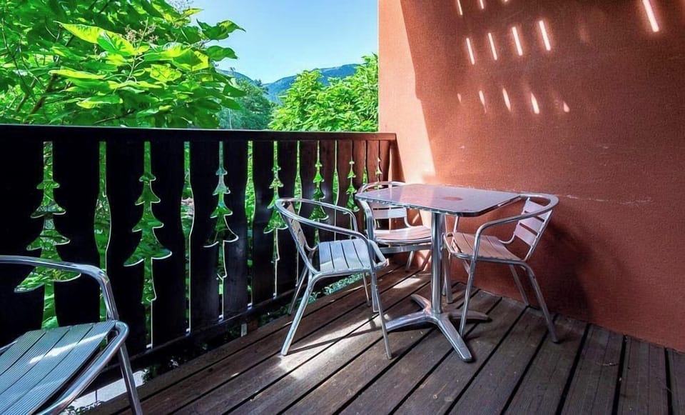 The balcony faces the ridgelines that frame the Ax 3 Domaines area, snow-capped or green.