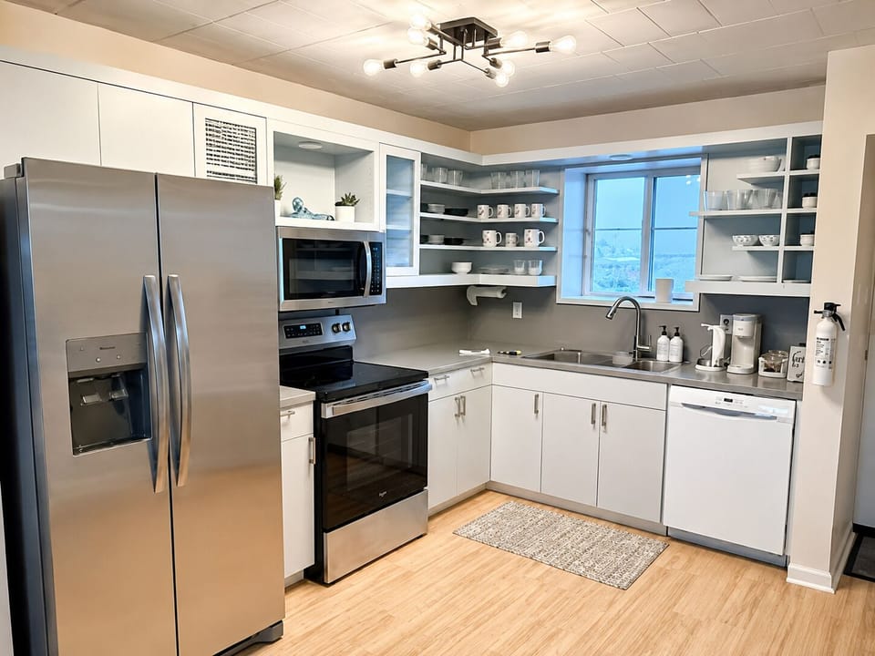 Bright modern kitchen with stainless appliances and open shelving
