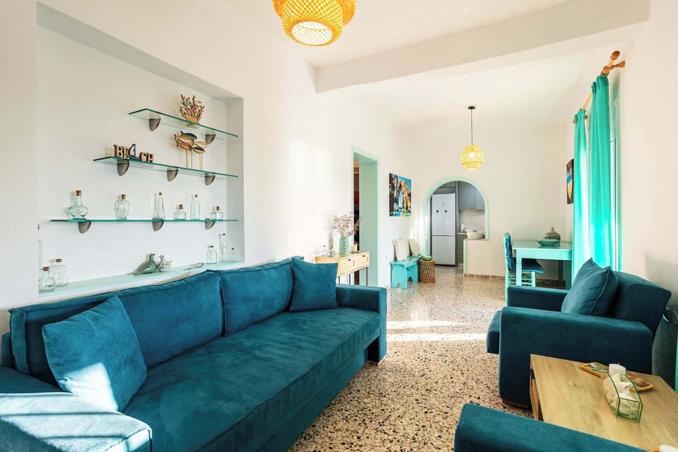 Bright living room with comfortable sofas, Smart TV, and plenty of natural light.
