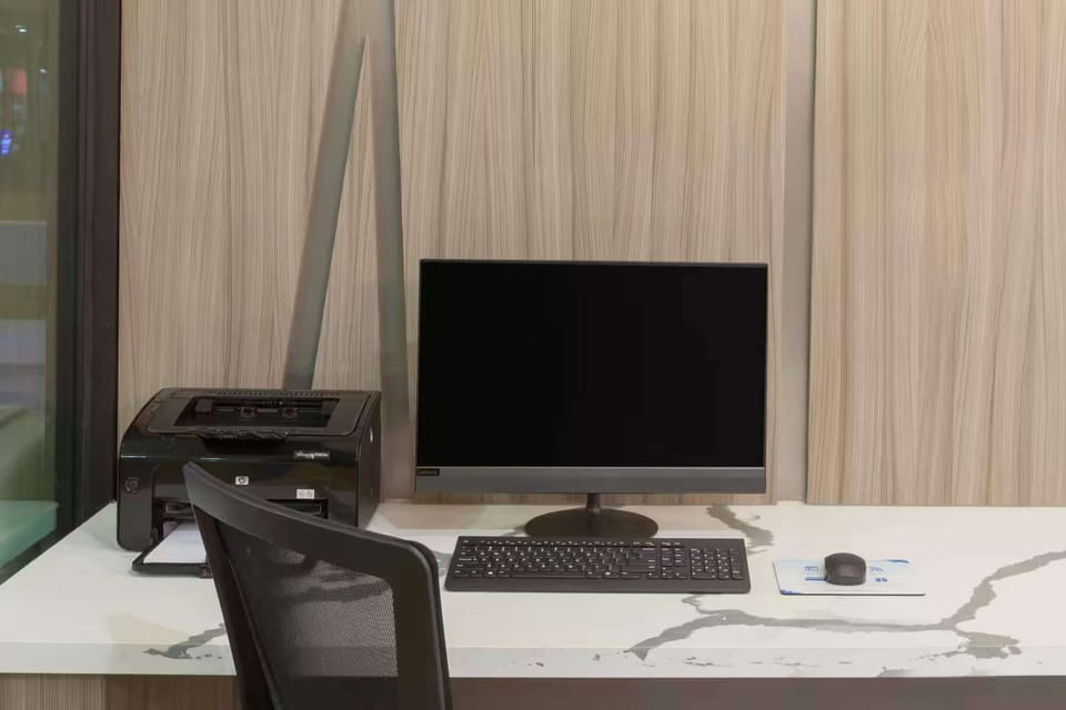 Business desk with computer, printer, and chair for work needs