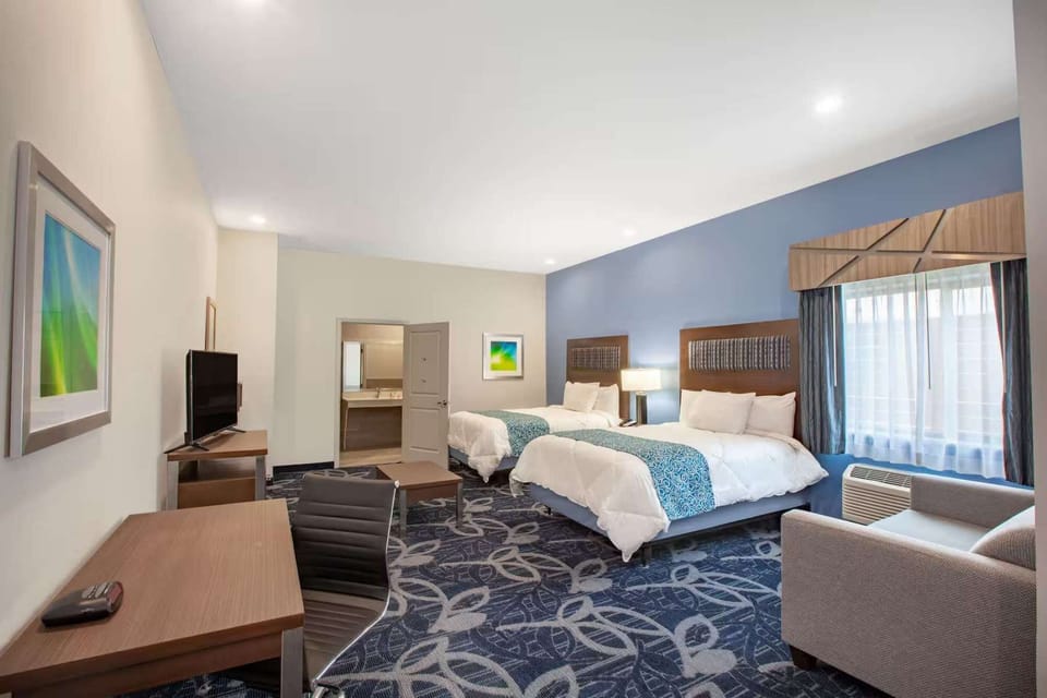 Two queen beds with desk, TV, and soft blue accents
