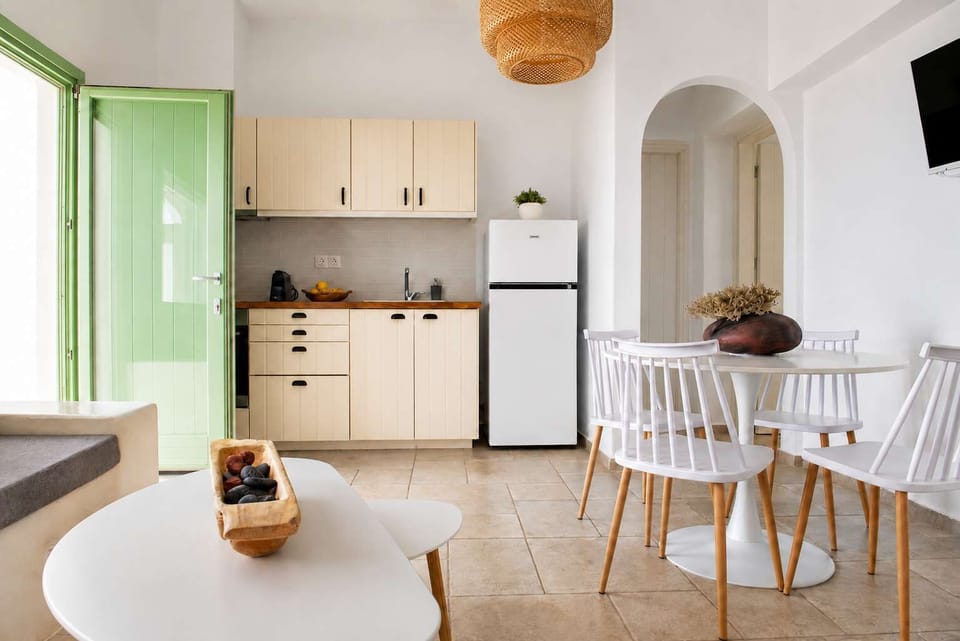 Apollonas - Stylish kitchen and dining area with soft green accents and modern amenities.