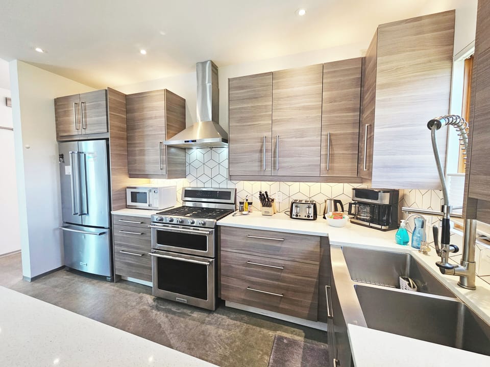 Our kitchen showcases a double-door stainless steel fridge and freezer, a 5-burner gas stove with a griddle