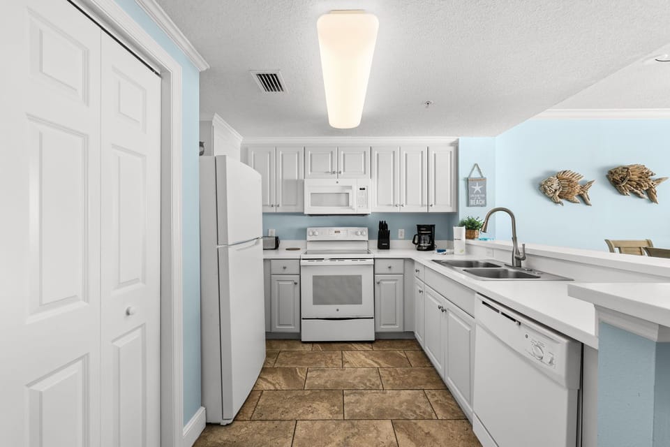 Modern kitchen with white cabinetry and appliances in a bright, open layout.