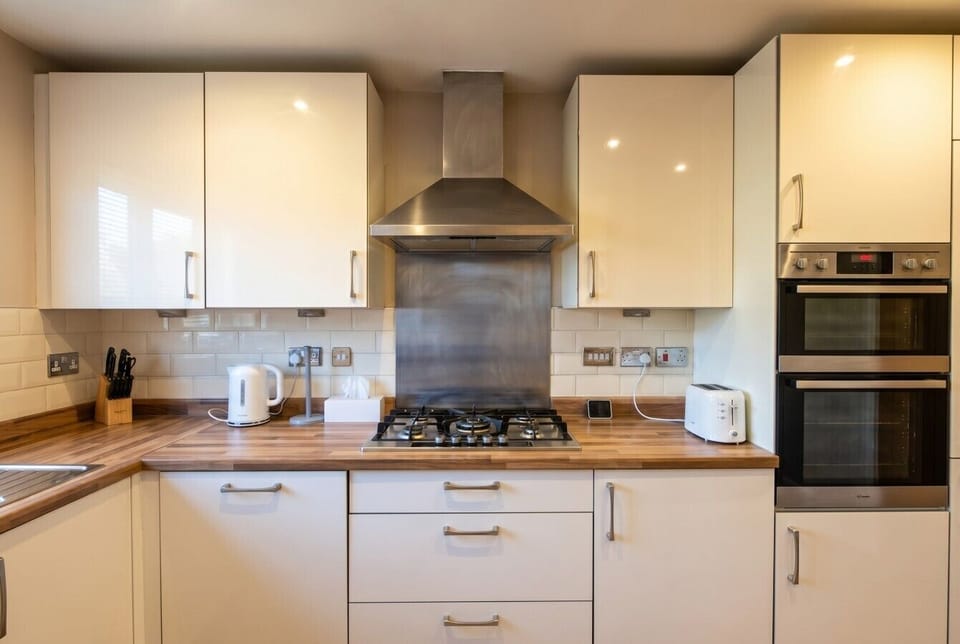 Sleek kitchen with double oven, gas hob and toaster ready for breakfast