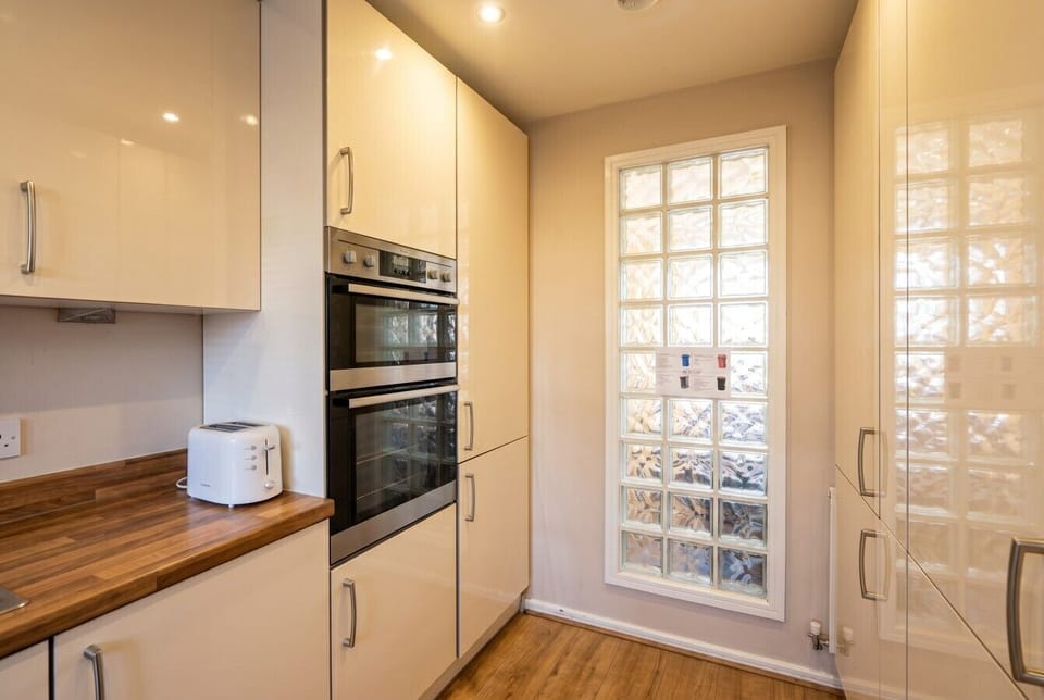 Practical kitchen with double oven, toaster and natural light