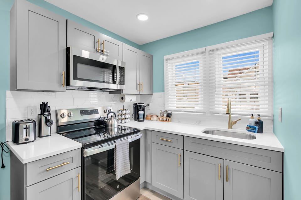 Bright modern kitchen with stainless appliances and sunny corner window
