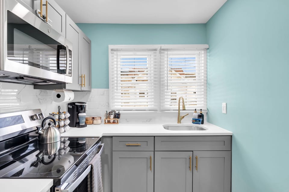 Bright modern kitchen with sunny windows and stylish gold accents