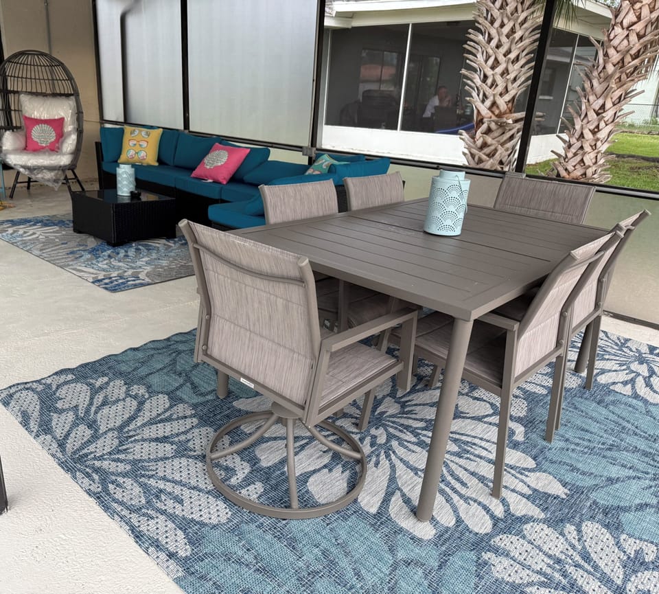 Pool deck lounge area overlooking the pool and canal, equipped with ceiling fan/