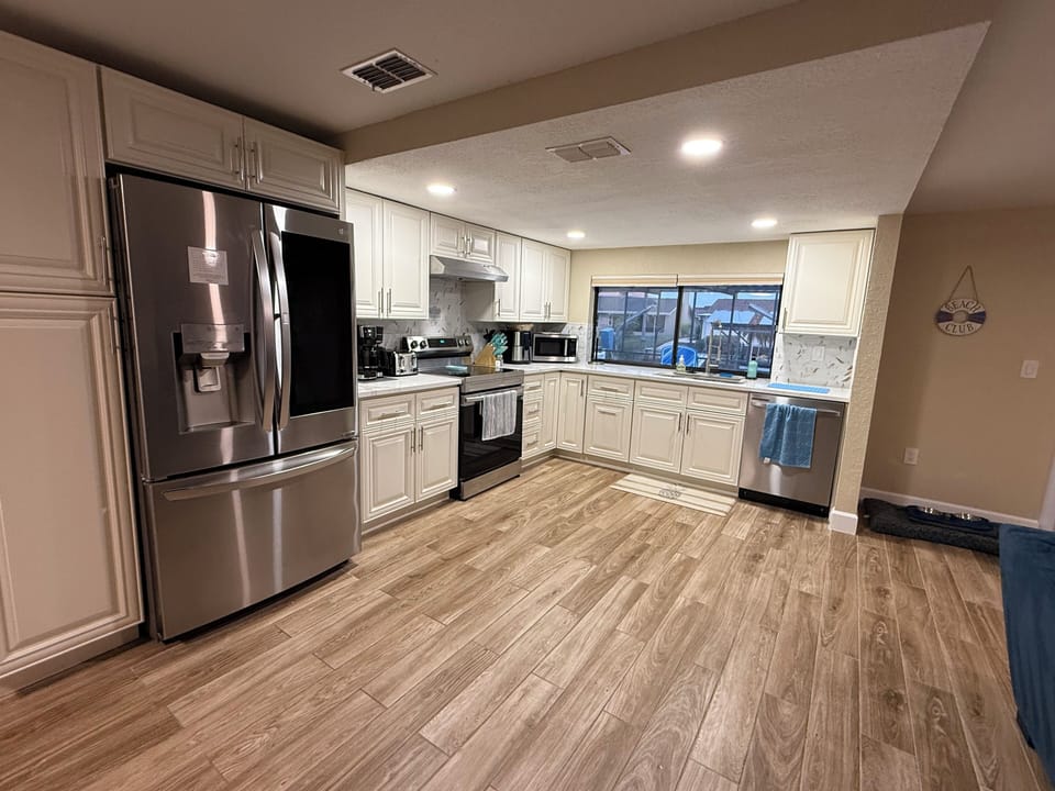 Spacious open concept fully equipped kitchen overlooking the pool and canal. 