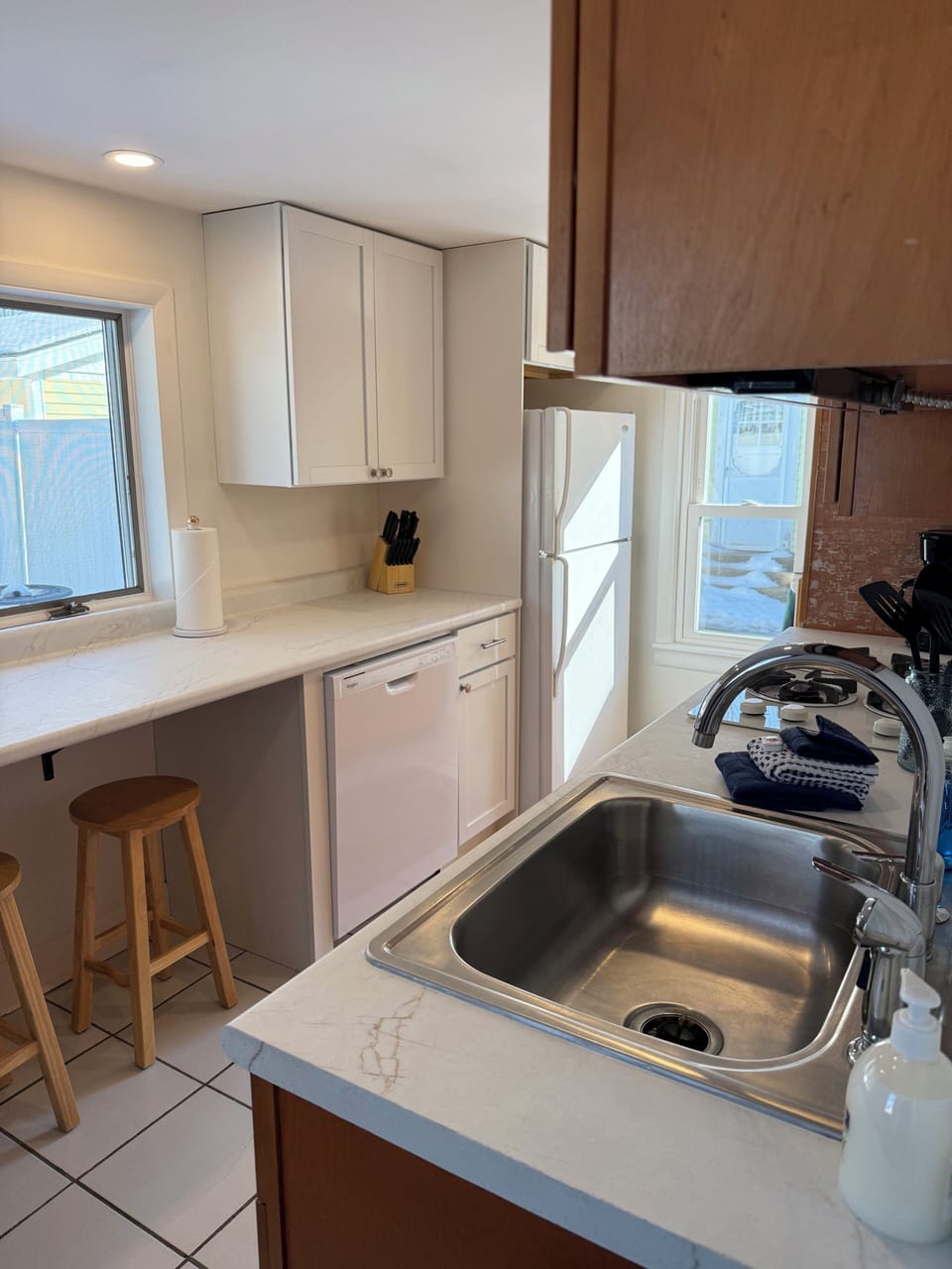 New white kitchen cabinets, countertop and dishwasher installed.