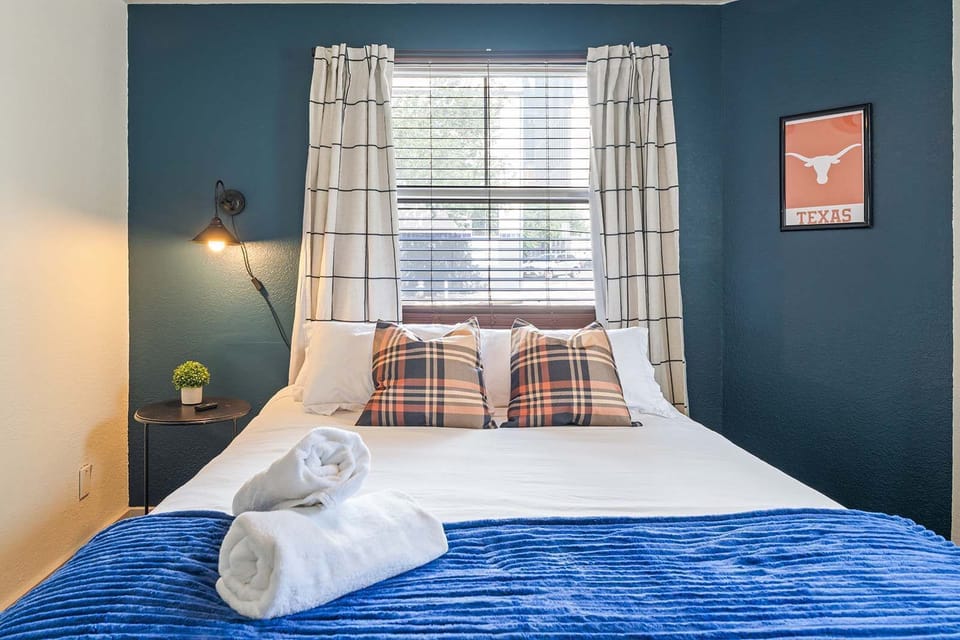 Relax in this cozy bedroom with a touch of Texas charm, featuring plush bedding and natural light.