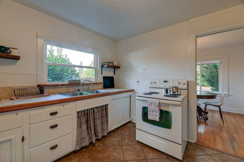 Kitchen | White Cabinetry & Tile Floors | Window Sink