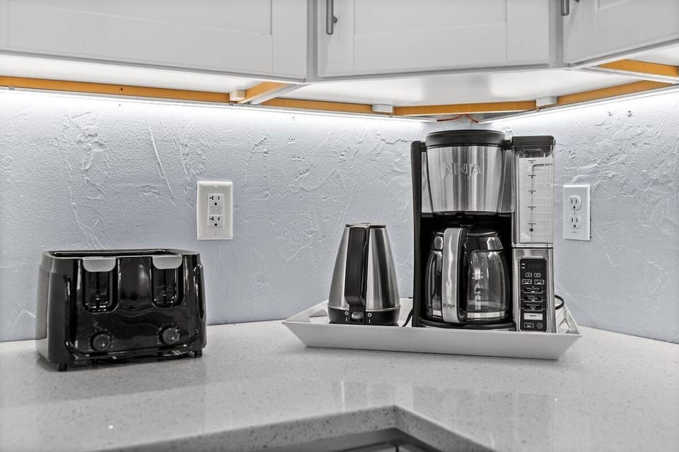 Bright kitchen coffee station with toaster, blender, and coffee maker