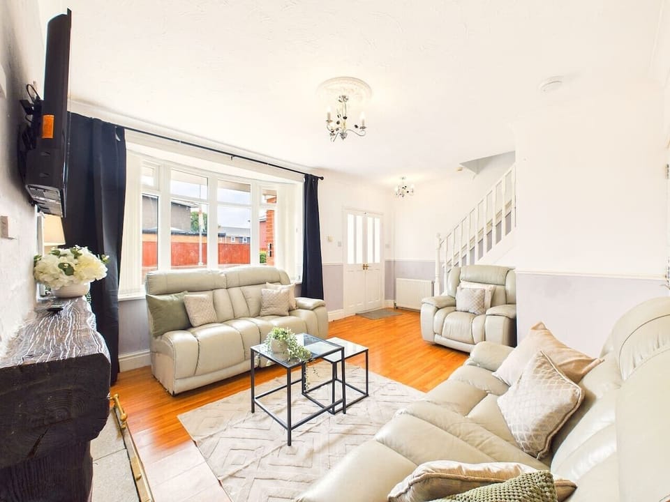 This bright living room beautifully balances modern comfort with fun tropical accent wallpaper, creating a warm, energetic atmosphere for your stay.