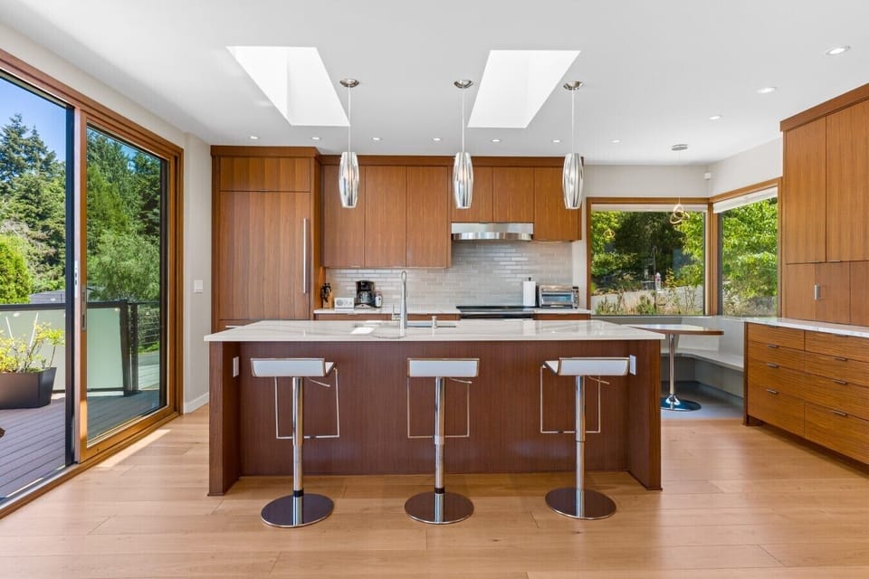 Skylit kitchen with waterfall island seating four.