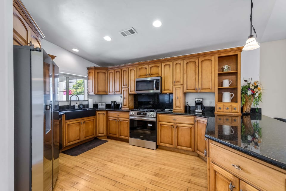 Stainless steel appliances, coffee maker, granite counters, and counter seating for 4 guests.