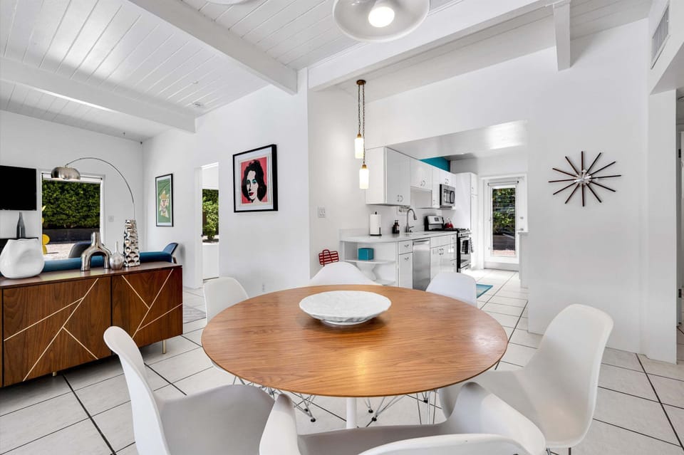 Round dining table beneath vaulted white-beamed ceilings