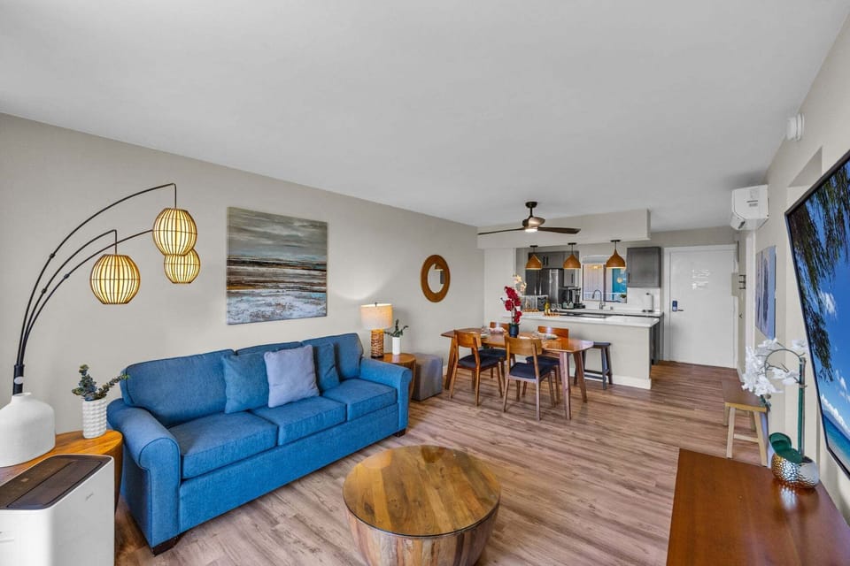 Relax in the spacious open-concept living area featuring comfortable furnishings, a dining table, and seamless indoor-outdoor living.