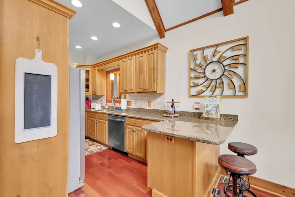 Whip up mountain meals in this warm wood kitchen, featuring sleek granite counters and breakfast bar seating—perfect for casual mornings or gathering while dinner comes together.