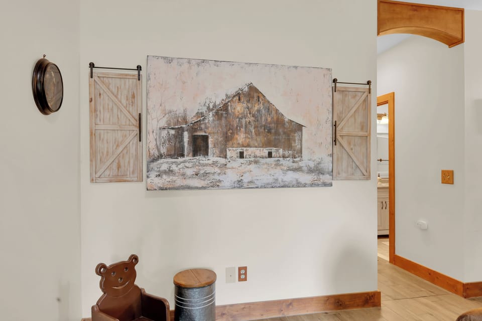 Rustic farmhouse wall art brings warm charm to this bright interior, adding a thoughtful, homey touch that rounds out the mountain-cabin feel throughout.