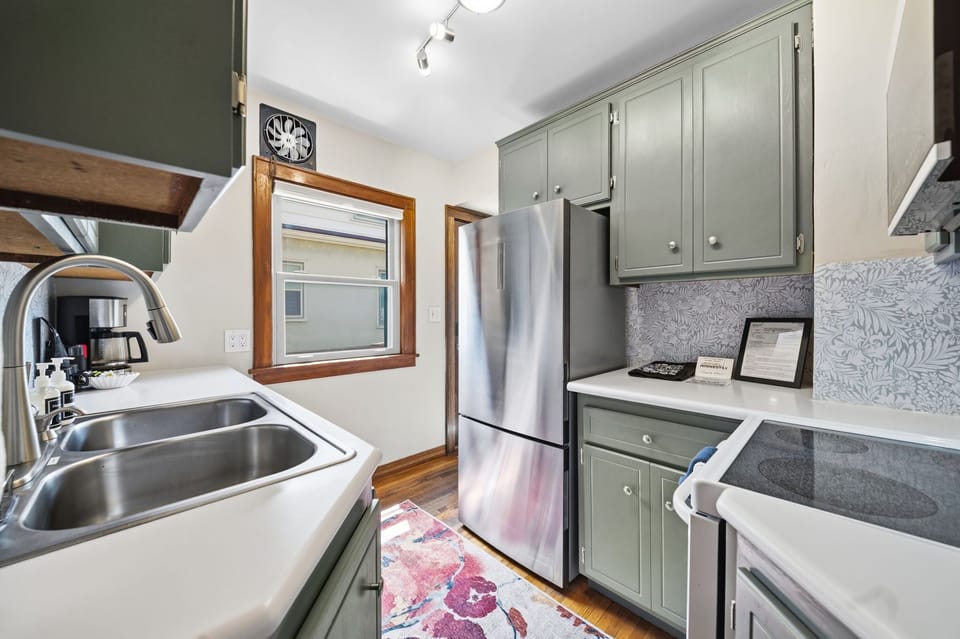 Your fully equipped kitchen awaits with sleek cabinetry, modern appliances, and charming details like patterned backsplash and warm wood trim to make meal prep a pleasure.