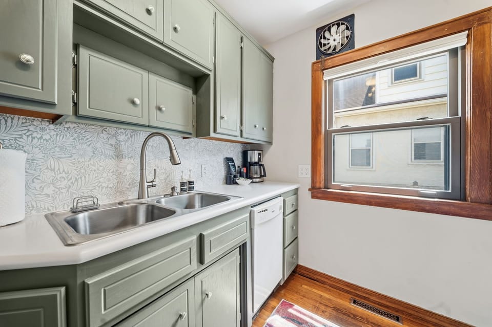 Your fully equipped kitchen features sage-green cabinets, a double sink, and everything you need to prepare meals during your stay.