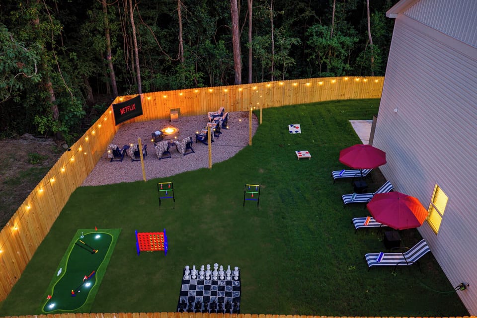 Game-filled backyard retreat with fire pit, movie screen, and lounge seating