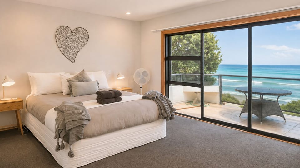 Spacious ocean-view bedroom with private balcony and outdoor seating