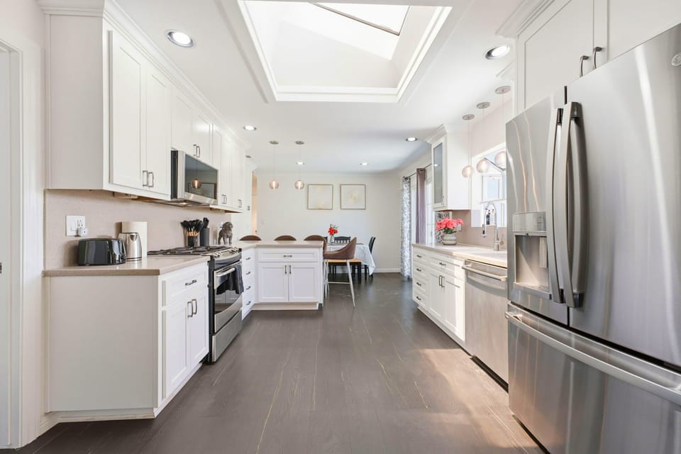 Bright modern kitchen with skylight, island, and stylish dining area