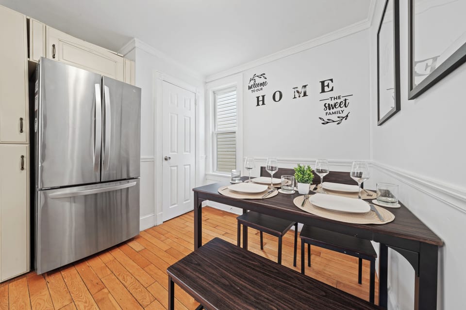 Bright dining nook with stylish seating and modern stainless kitchen touches