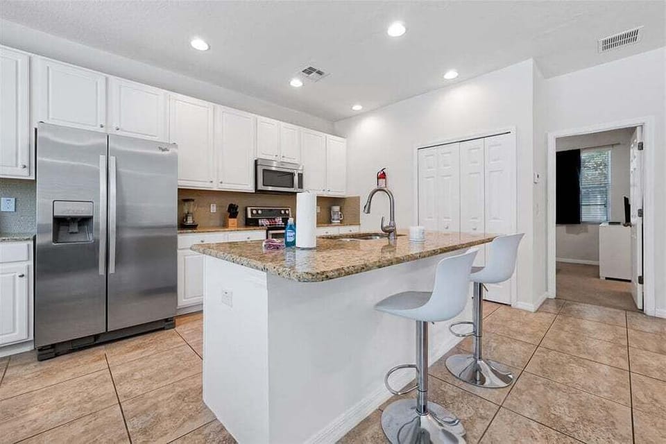 Prepare everything from quick breakfasts to family dinners in the fully equipped kitchen, complete with stainless steel appliances, granite countertops, and convenient bar seating.