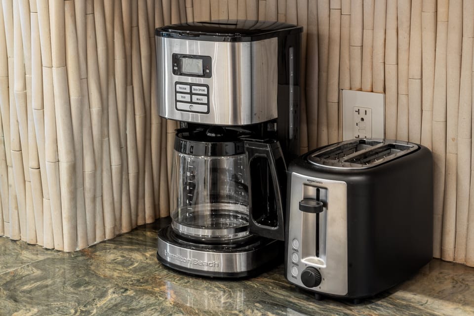 A close-up of the essential small appliances provided, including a multi-cup drip coffee maker and a stainless steel toaster.