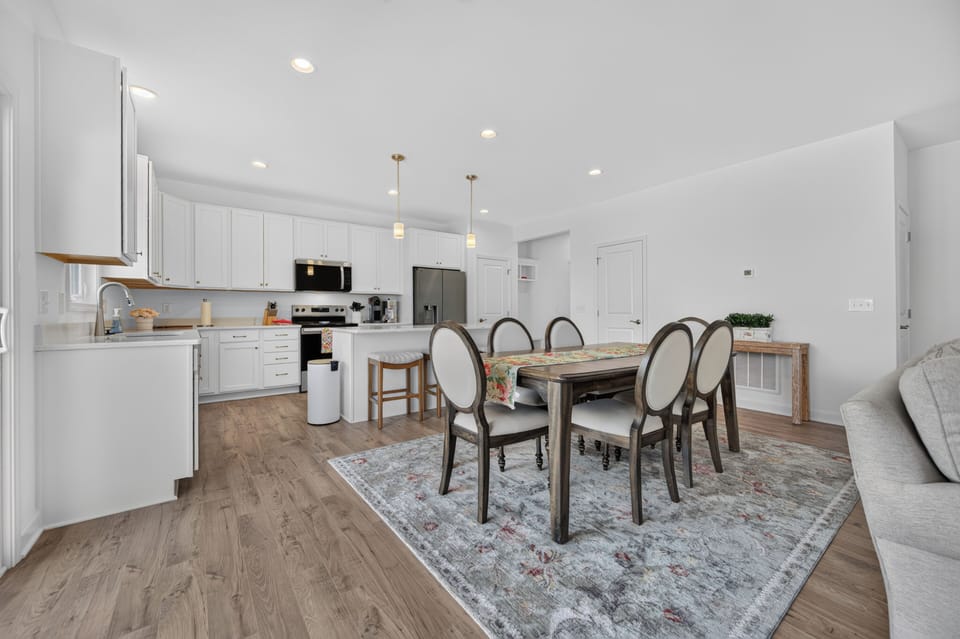 Enjoy meals in a bright, open-concept dining area adjacent to a modern kitchen with island seating.