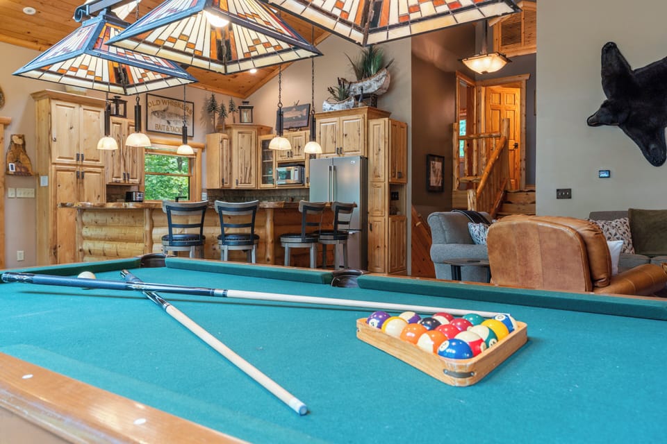 Challenge friends to a game of pool while enjoying the cabin's open-concept living, complete with rustic wood finishes and cozy seating areas just steps away.
