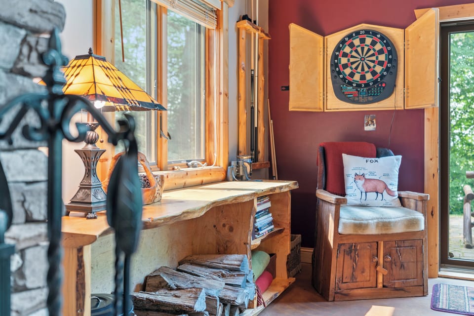 Challenge yourself to a game of darts or unwind with a book in this charming nook where natural light pours through the windows and rustic details invite relaxation.
