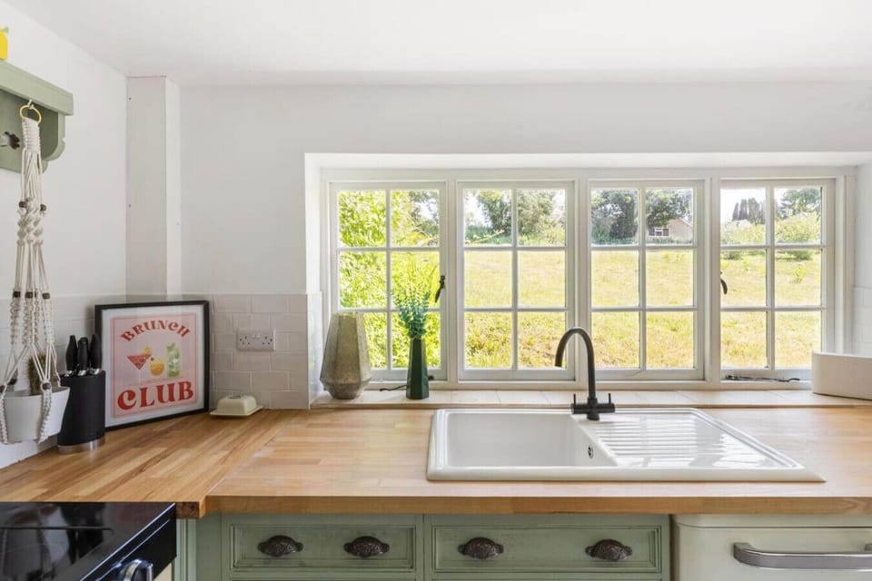 Belfast sink framed by wide windows over rolling countryside